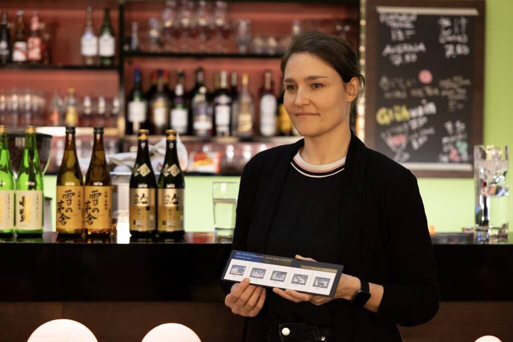 Sake-Sommelier erklärt den Reispoliergrad mit Anschauungsmaterial.
